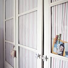 Un armario con cristal y cortinillas de tela